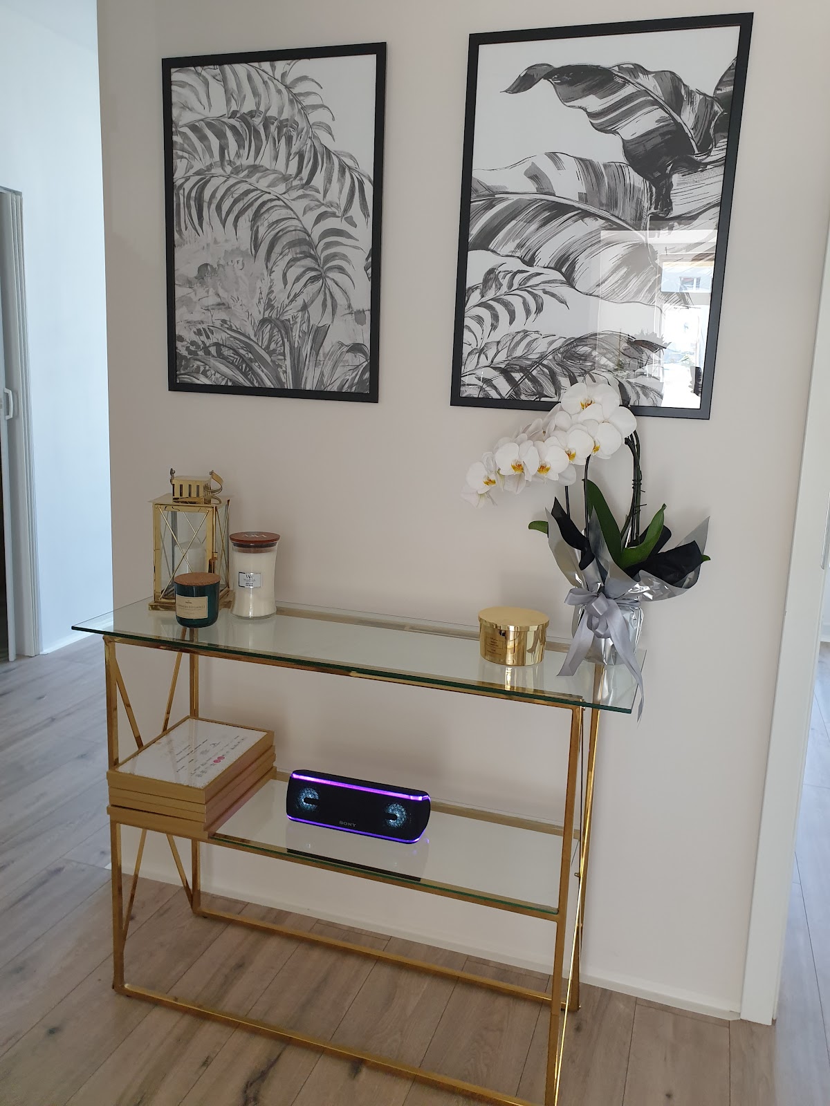 Wnętrze salonu Beauty Lab, złota konsola z orchideą i świecami