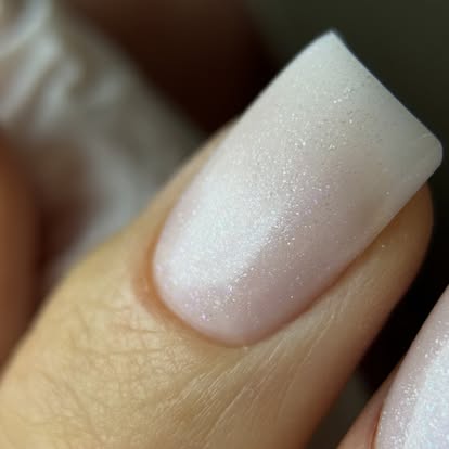 Delikatny różowy manicure z drobnym brokatem